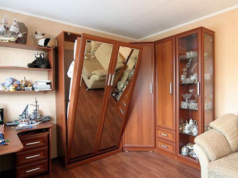 Lit pliant dans une armoire avec une façade en miroir