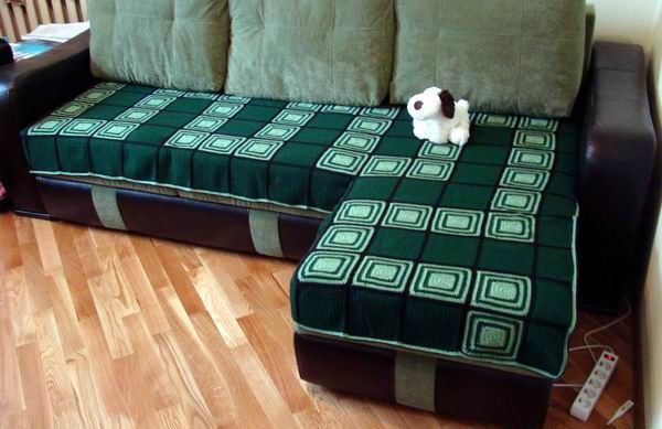 Couverture verte sur un canapé d'angle