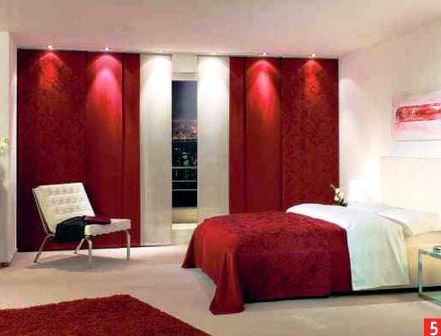 Le lit rouge rend la chambre plus confortable